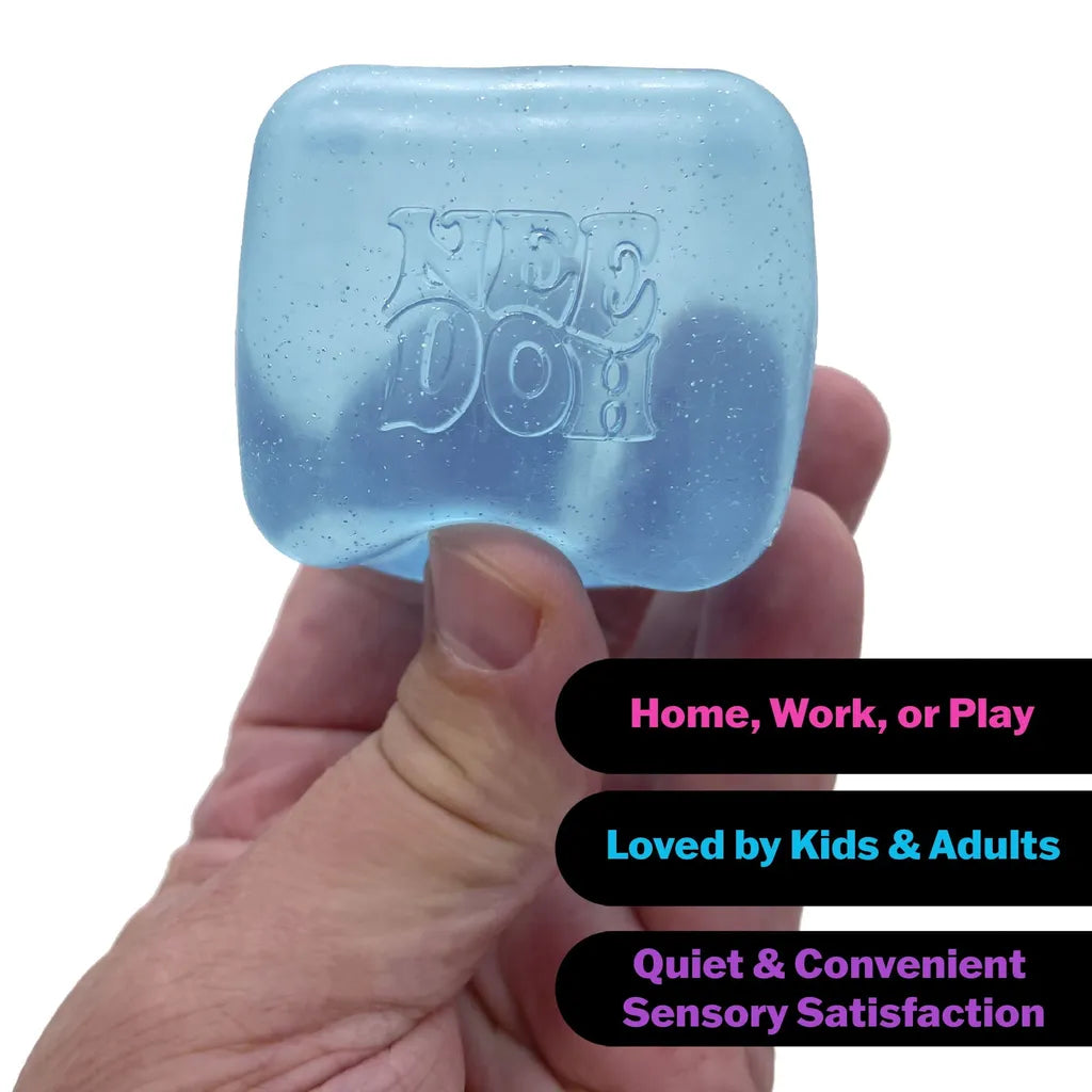Hand holding translucent blue NEE DOH cube with glitter, labeled for home/work/play sensory satisfaction